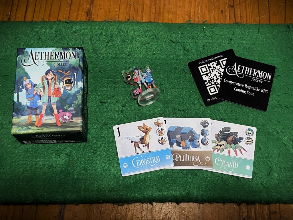 image of Aethermon: Collect, showing the game box, the plastic figurine, and three different monsters to collect in game. 