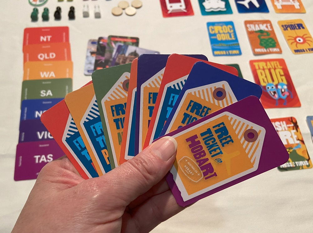 Image of some cards used in the tabletop game, TRAVEL BUG, including "Free Ticket to Hobart"